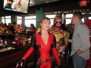 A women in a red costume next to a man in an iron man costume