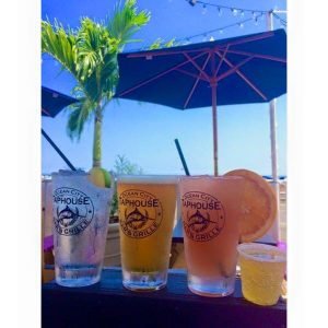 three glasses outside under a navy blue beach umbrella