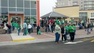a group of people outside Traphouse bar and grill dressed in all green