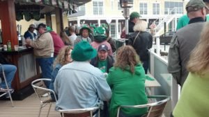 people dressed in green sitting around a table outside